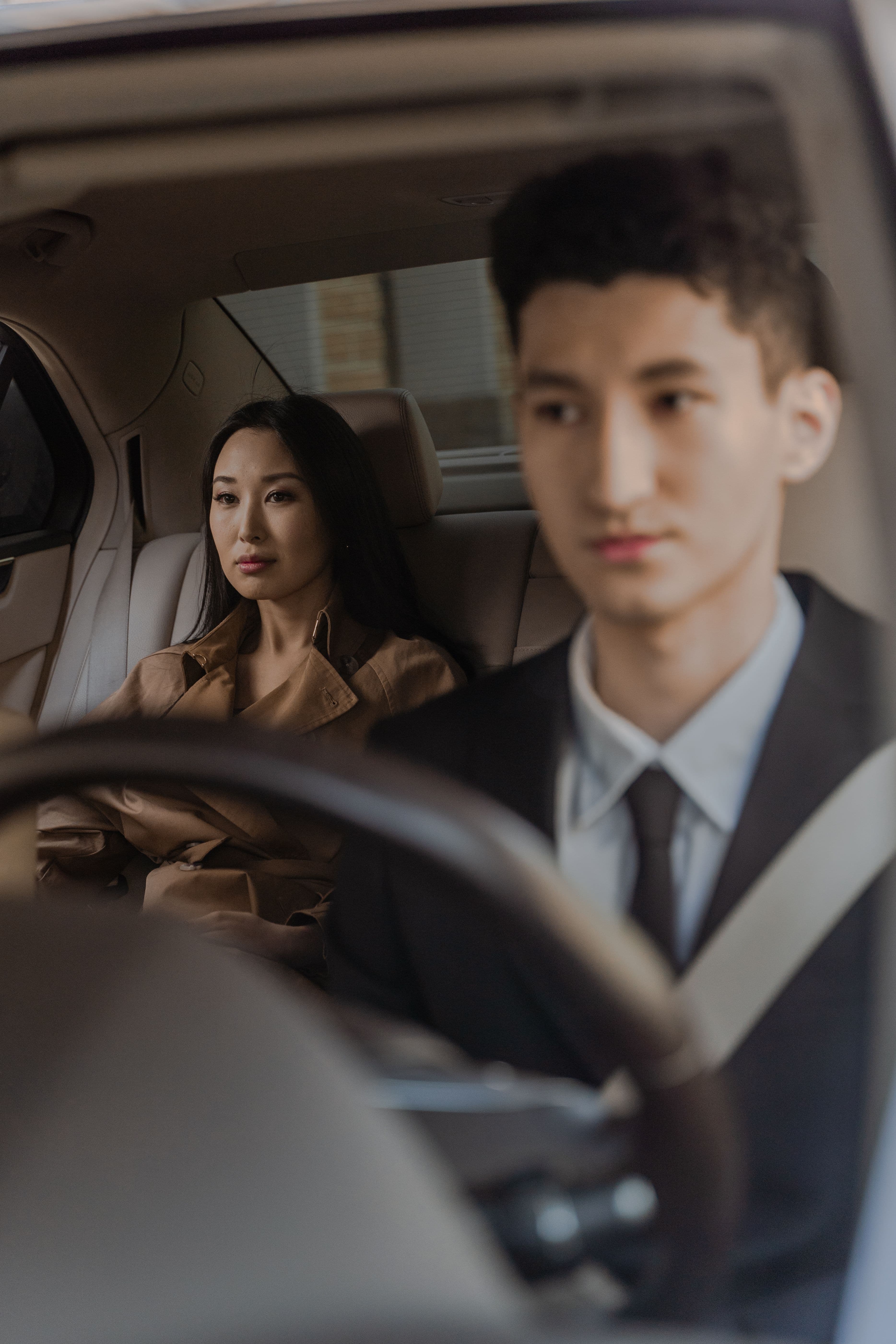 Professional chauffeur and passenger travelling in a premium vehicle