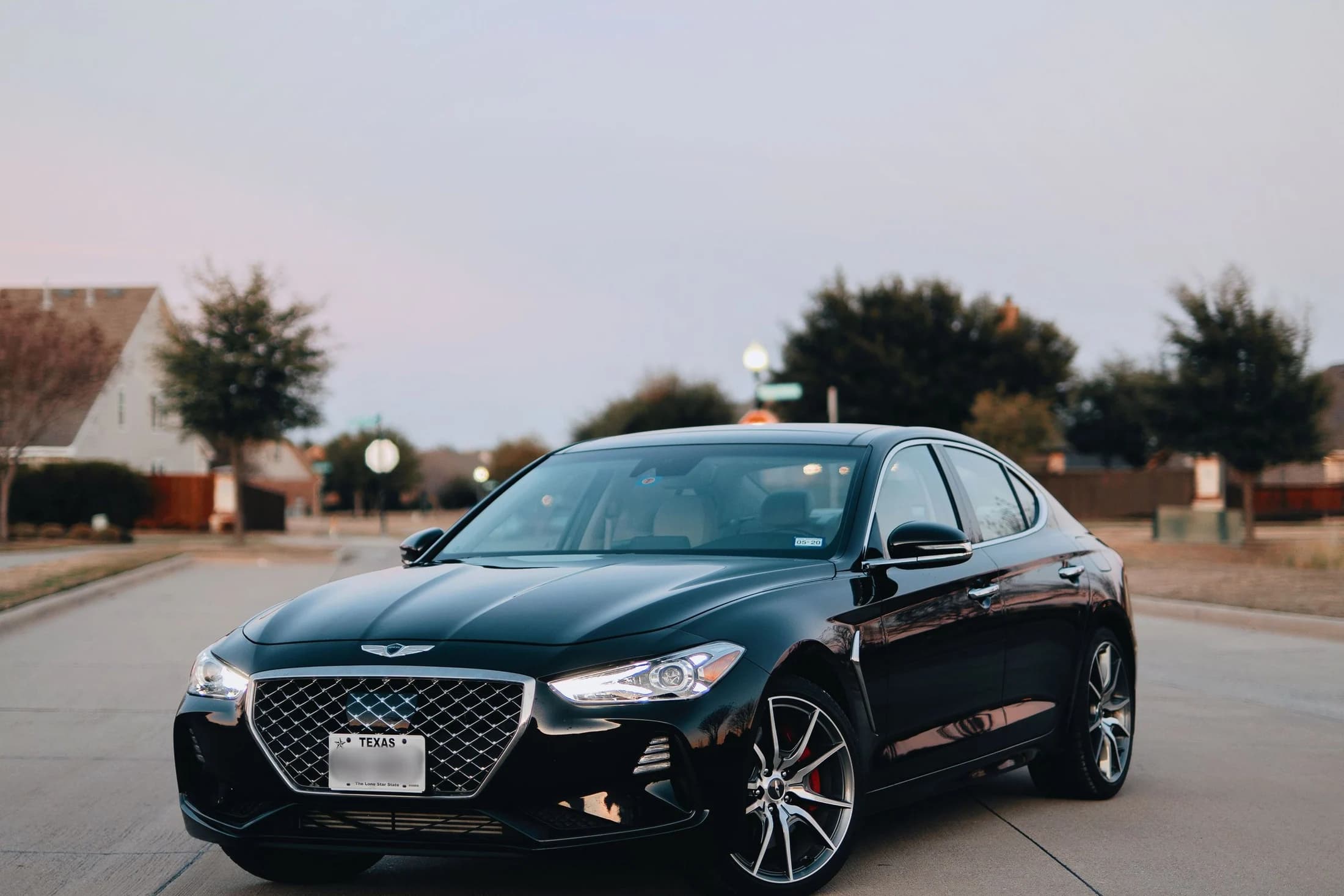 Black executive sedan parked on a quiet road